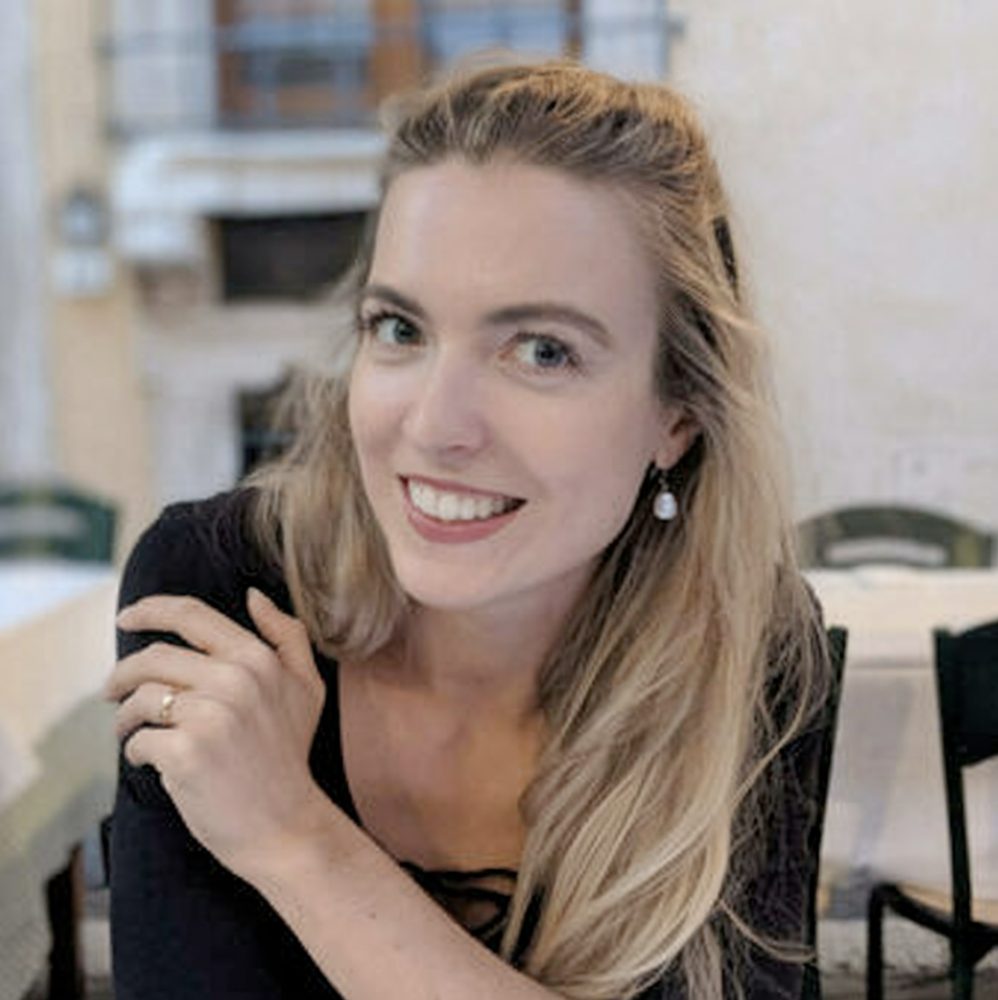 Grace, smiling, seated at a café table